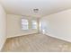 Well-lit bedroom with carpeted floors and neutral walls at 7534 April Mist Trl, Huntersville, NC 28078