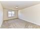 Well-lit bedroom featuring a large window and neutral walls at 7534 April Mist Trl, Huntersville, NC 28078