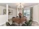 Traditional dining room with modern table and seating, chandelier lighting, and natural light from large window at 7534 April Mist Trl, Huntersville, NC 28078