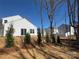 The backyard features newly planted trees and a sliding glass door to the home at 8205 Stonemere Ln, Charlotte, NC 28215