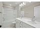 Bright bathroom with double sinks, white cabinets, and shower-tub combo at 8205 Stonemere Ln, Charlotte, NC 28215