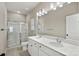 The main bathroom includes double sinks, quartz countertops, and a tile and glass enclosed shower at 8205 Stonemere Ln, Charlotte, NC 28215