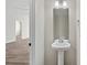 Powder room with pedestal sink and an adjoining room with modern floors at 8205 Stonemere Ln, Charlotte, NC 28215