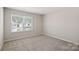 This bedroom features neutral walls, carpeted floor, and one window at 8205 Stonemere Ln, Charlotte, NC 28215