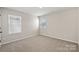 This bedroom features neutral walls, carpeted floor, and two windows at 8205 Stonemere Ln, Charlotte, NC 28215