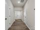 Neutral hallway with wood-look floors, white trim, and multiple doorways at 8205 Stonemere Ln, Charlotte, NC 28215