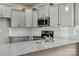 A close up of the kitchen, featuring stainless appliances, gray cabinets, and granite countertops at 8205 Stonemere Ln, Charlotte, NC 28215