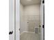 Functional laundry room features a tiled floor, utility connections, and shelving for storage at 8205 Stonemere Ln, Charlotte, NC 28215