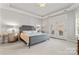 Spacious bedroom with a tray ceiling, neutral carpet, and a doorway leading to a patio at 1236 Avalon Pl, Matthews, NC 28104