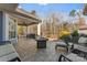 Covered patio with an outdoor fireplace, stylish seating, ceiling fan, and view of a wooded backyard at 1236 Avalon Pl, Matthews, NC 28104