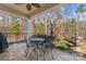 Covered patio with dining table, ceiling fan, an outdoor water feature, and wooded backyard at 1236 Avalon Pl, Matthews, NC 28104