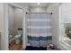 Cozy bathroom features a shower with a striped curtain, a window, and a toilet at 170 Stillwater Rd, Richfield, NC 28137