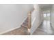 Bright hallway with carpeted stairs, wood railing, and wood-look floors leading to a sunlit area at 3033 Eastcott Ave, Monroe, NC 28110