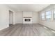 Bright living room with an electric fireplace, shiplap accent wall, and gray wood-look floors at 3033 Eastcott Ave, Monroe, NC 28110