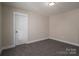 Simple bedroom with grey carpet, and an open door to the hallway at 511 E Sycamore St, Lincolnton, NC 28092