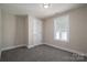 Well-lit bedroom with grey carpet, a window, and an adjacent closet at 511 E Sycamore St, Lincolnton, NC 28092