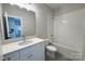 Bathroom with a combined tub and shower, toilet, vanity with countertop, and a large mirror at 1875 Rock Hill Church Rd # 4, Matthews, NC 28104