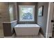 Close up of the bathtub in the bathroom, showcasing its modern design and view of the backyard at 1875 Rock Hill Church Rd # 4, Matthews, NC 28104