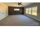 Spacious bedroom featuring modern trim wall, plush carpeting, ceiling fan, and a sunlit view at 1875 Rock Hill Church Rd # 4, Matthews, NC 28104