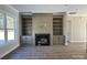 Inviting living room featuring hardwood floors, built in shelving, and fireplace at 1875 Rock Hill Church Rd # 4, Matthews, NC 28104