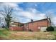 Expansive backyard with a brick house, a covered patio, a well-maintained lawn, and beautiful landscaping at 216 Delview Dr, Cherryville, NC 28021