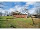 Spacious backyard featuring a gentle slope, mature trees, and ample room for outdoor activities at 216 Delview Dr, Cherryville, NC 28021