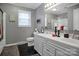 Bathroom with double vanity, sleek modern fixtures, framed mirror, and contrasting black tile floor at 216 Delview Dr, Cherryville, NC 28021