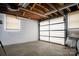 A spacious garage featuring a functional garage door, white brick walls, and ample storage area at 216 Delview Dr, Cherryville, NC 28021