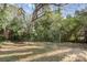 Overgrown backyard with mature trees and a fence at 2630 Druid Hills Way, Charlotte, NC 28206