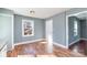Empty room features blue walls, wood floors, a single window, and view into an adjacent room at 2630 Druid Hills Way, Charlotte, NC 28206