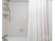 Clean bathroom with shower/tub combo and white tile at 4754 Hedgemore Dr # S, Charlotte, NC 28209