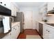 Kitchen with white cabinets, stainless steel appliances, and hardwood floors at 4754 Hedgemore Dr # S, Charlotte, NC 28209