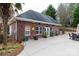 Brick pool house with a dark roof, multiple windows, and a large concrete patio area at 1038 Rolling Park Ln, Fort Mill, SC 29715