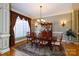 A beautifully staged dining room with hardwood floors, a classic table set, and elegant window treatments at 1038 Rolling Park Ln, Fort Mill, SC 29715