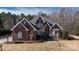 A stately brick home with well-maintained landscaping and elegant architectural details under a partly cloudy sky at 1038 Rolling Park Ln, Fort Mill, SC 29715