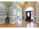 A grand foyer with hardwood floors, decorative trim, and a view into the study through glass french doors at 1038 Rolling Park Ln, Fort Mill, SC 29715