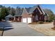 Brick home with a three-car garage, well-manicured lawn, and long driveway on a sunny day at 1038 Rolling Park Ln, Fort Mill, SC 29715