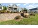 Stone retaining wall and tiered landscaping lead to a home's expansive deck at 112 Sisters Cove Ct, Mooresville, NC 28117