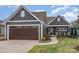 Charming gray home featuring a brown garage door, manicured lawn, and a welcoming covered front porch at 112 Sisters Cove Ct, Mooresville, NC 28117