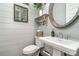 Chic powder room featuring gray shiplap walls, a decorative mirror, and a pedestal sink at 112 Sisters Cove Ct, Mooresville, NC 28117