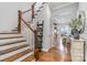 Staircase with hardwood steps and white railing, leading to an open living area filled with light at 112 Sisters Cove Ct, Mooresville, NC 28117