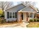 Gray house with a covered porch, brick columns, and black shutters at 267 Elm Nw Ave, Concord, NC 28025