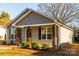 Gray house with a covered porch, brick columns, and black shutters at 267 Elm Nw Ave, Concord, NC 28025