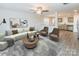 Open living room with L-shaped sofa, coffee table, and view into kitchen at 267 Elm Nw Ave, Concord, NC 28025