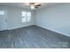 Living room with gray vinyl flooring, white walls, and a ceiling fan at 267 Elm Nw Ave, Concord, NC 28025