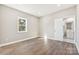 Spacious bedroom with hardwood floors, neutral walls, a window, and a view into an en suite bathroom at 287 Young Sw Ave, Concord, NC 28025