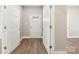 Hallway with hardwood style flooring and multiple white doors at 287 Young Sw Ave, Concord, NC 28025