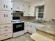 Classic kitchen with white cabinets, granite countertops, and black and white appliances at 2040 Ne 25Th Street Dr, Hickory, NC 28601