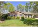 Charming brick home featuring blue shutters, mature landscaping, a well-manicured lawn, and a covered porch at 5431 Park Rd, Charlotte, NC 28209