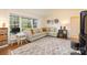 Cozy living room featuring a comfortable sectional sofa, large windows, and stylish decor with a desk area at 5431 Park Rd, Charlotte, NC 28209